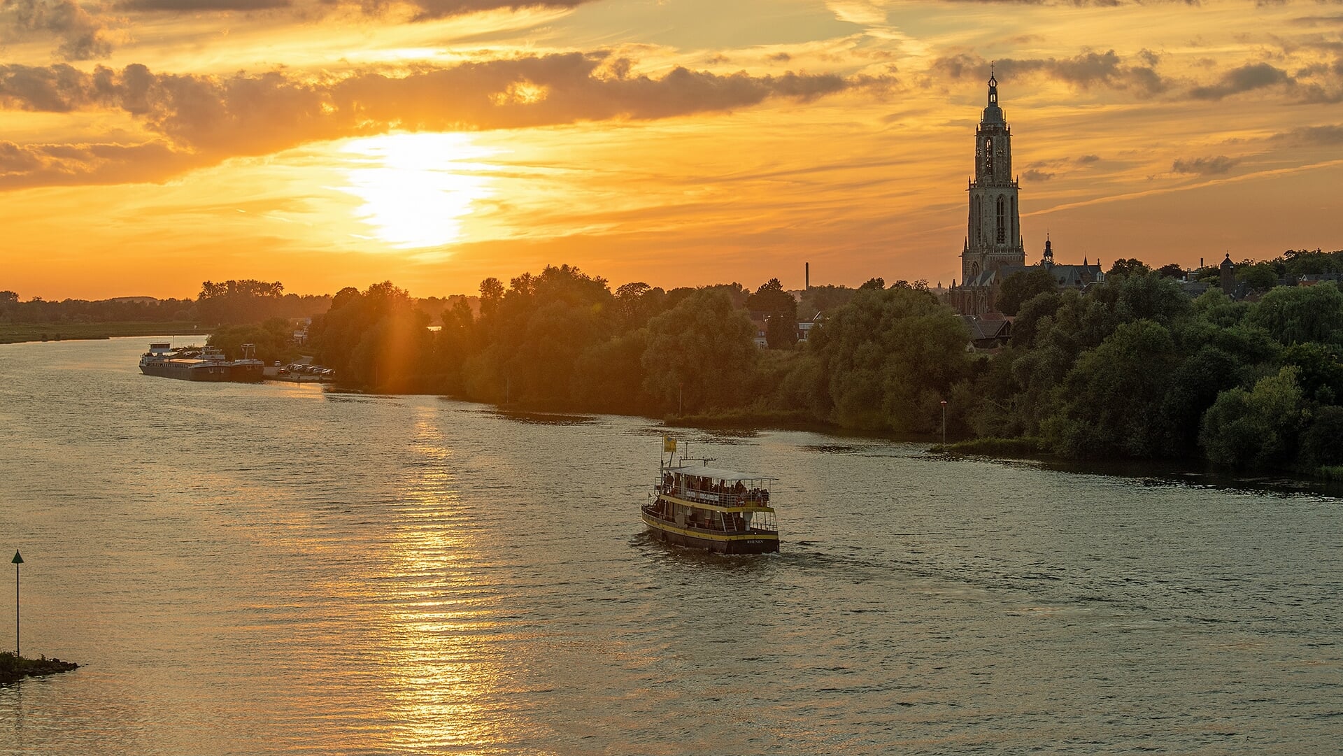 Rondvaartboot op de rivier bij zonsondergang